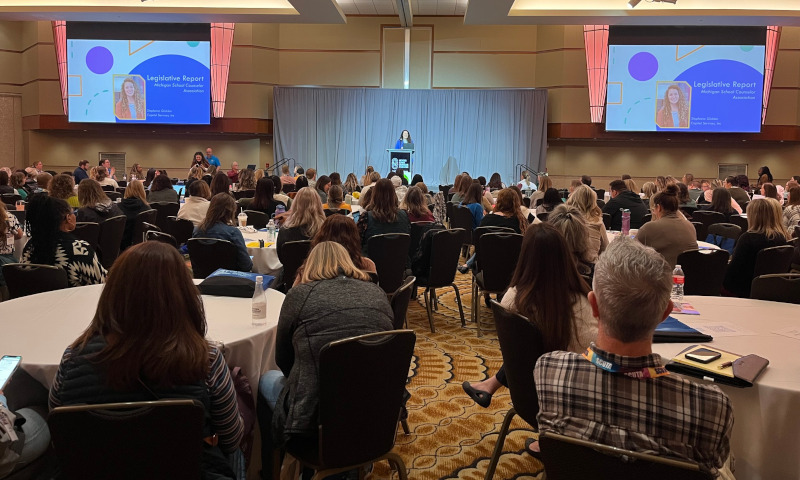 Attendees seated at round tables during a general session at the Michigan School Counselor Association Conference.
