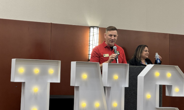 Two presenters speaking at a podium