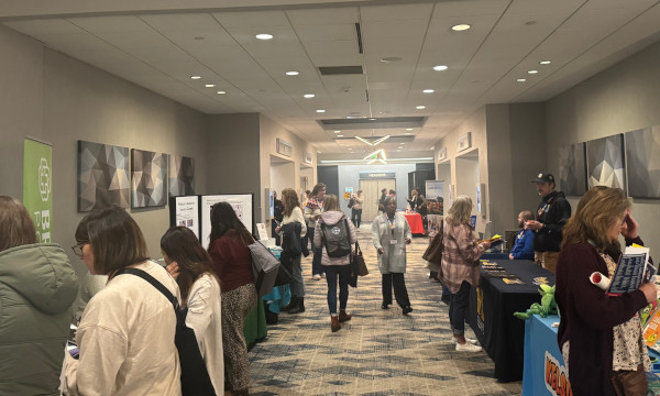 School counselors exploring exhibitor booths and networking in a conference exhibit hall.