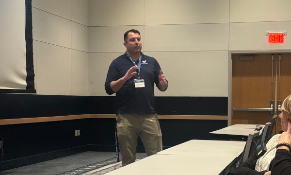 Conference speaker presenting to school counselors during a breakout training session.