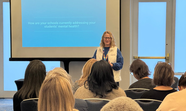 School counselor conference presenter leading a breakout session on student mental health.