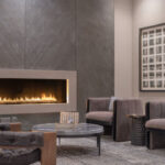 Sitting area in a hotel with a fire, chairs, and a coffee table
